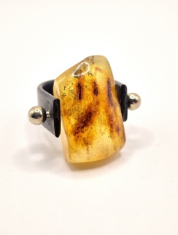 Nowoczesny pierścionek z naturalnym bursztynem osadzonym w lekkiej oprawie z tworzywa i stali szlachetnej