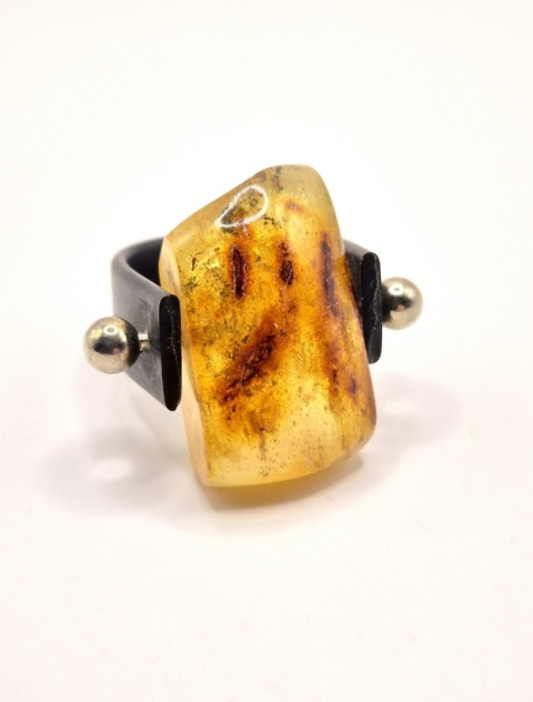 Nowoczesny pierścionek z naturalnym bursztynem osadzonym w lekkiej oprawie z tworzywa i stali szlachetnej